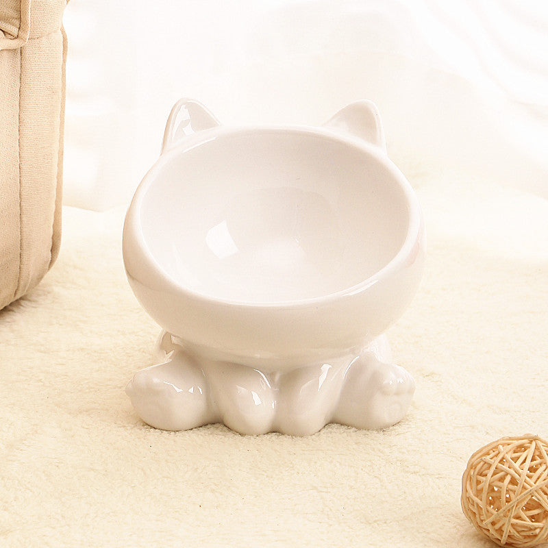 Ceramic cat bowl with cat-shaped design and raised neck guard on cream carpet.