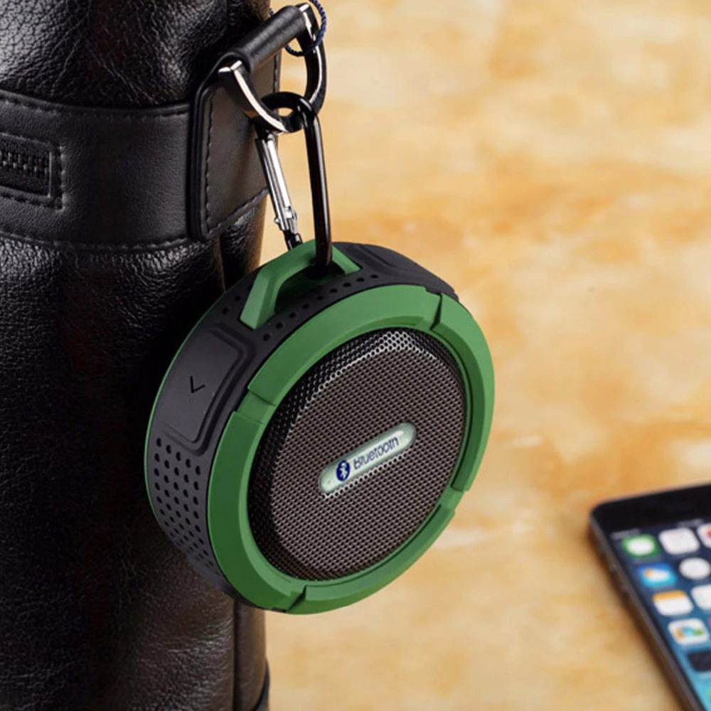 Mini portable waterproof Bluetooth speaker with suction cup hanging on a bag.