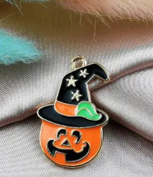 Halloween-themed pendant with witch hat and pumpkin design on a fabric background