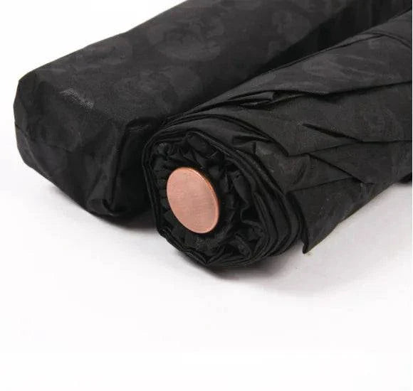 Folding umbrella with skull design, compact and durable.